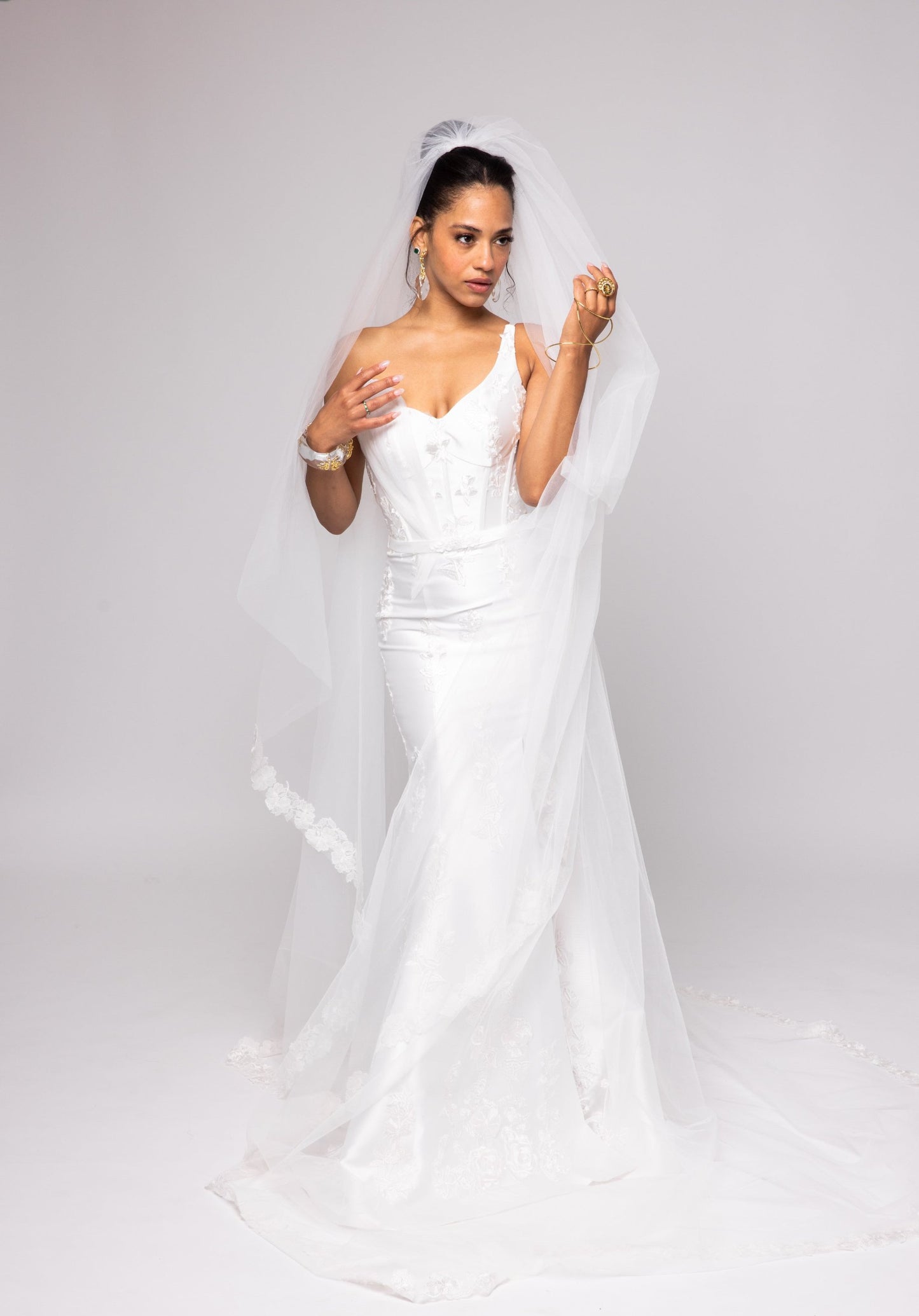 Off-white Mikado gown with embroidered lace, one shoulder with tulle detail over left bust. Detachable peplum.