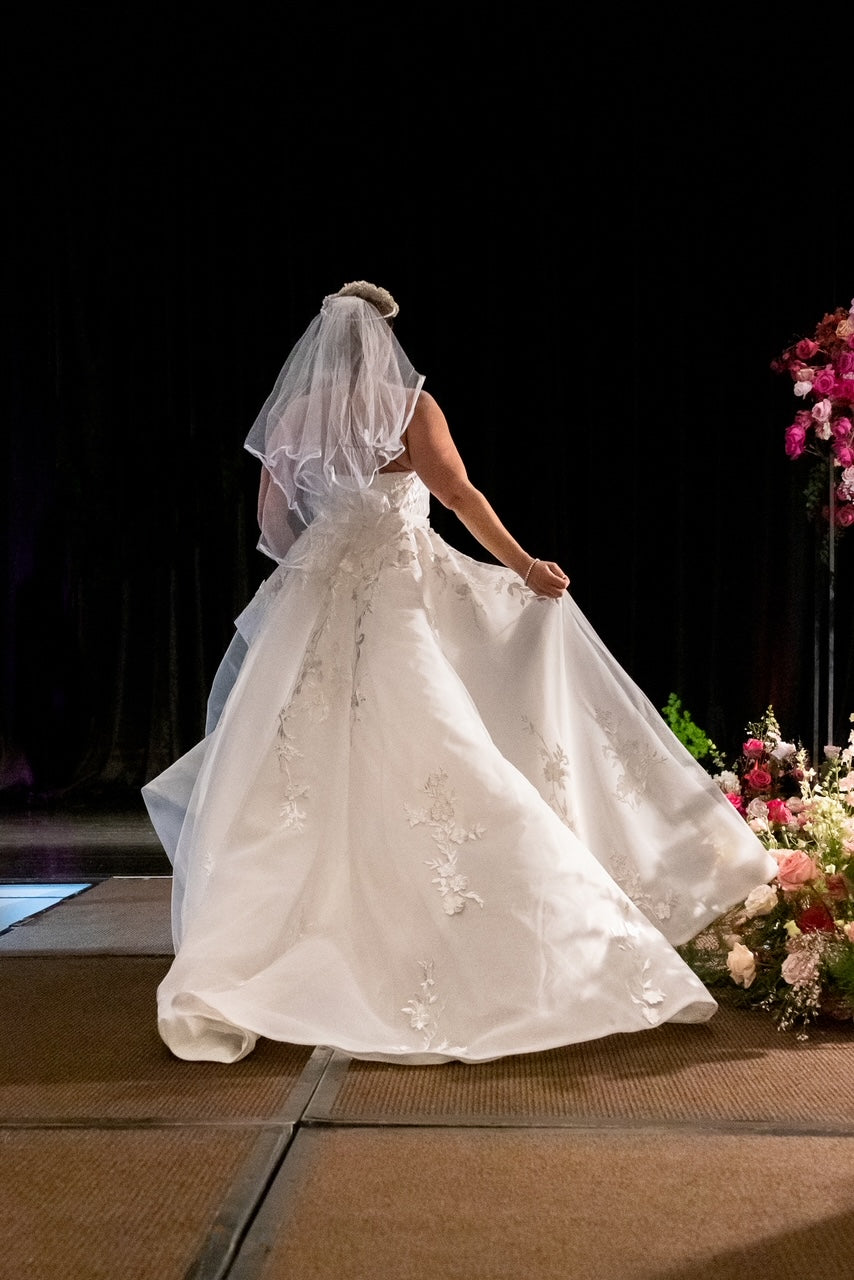 Off-white strapless Italian satin gown with embroidered lace detail; embroidered dramatic long detachable train.