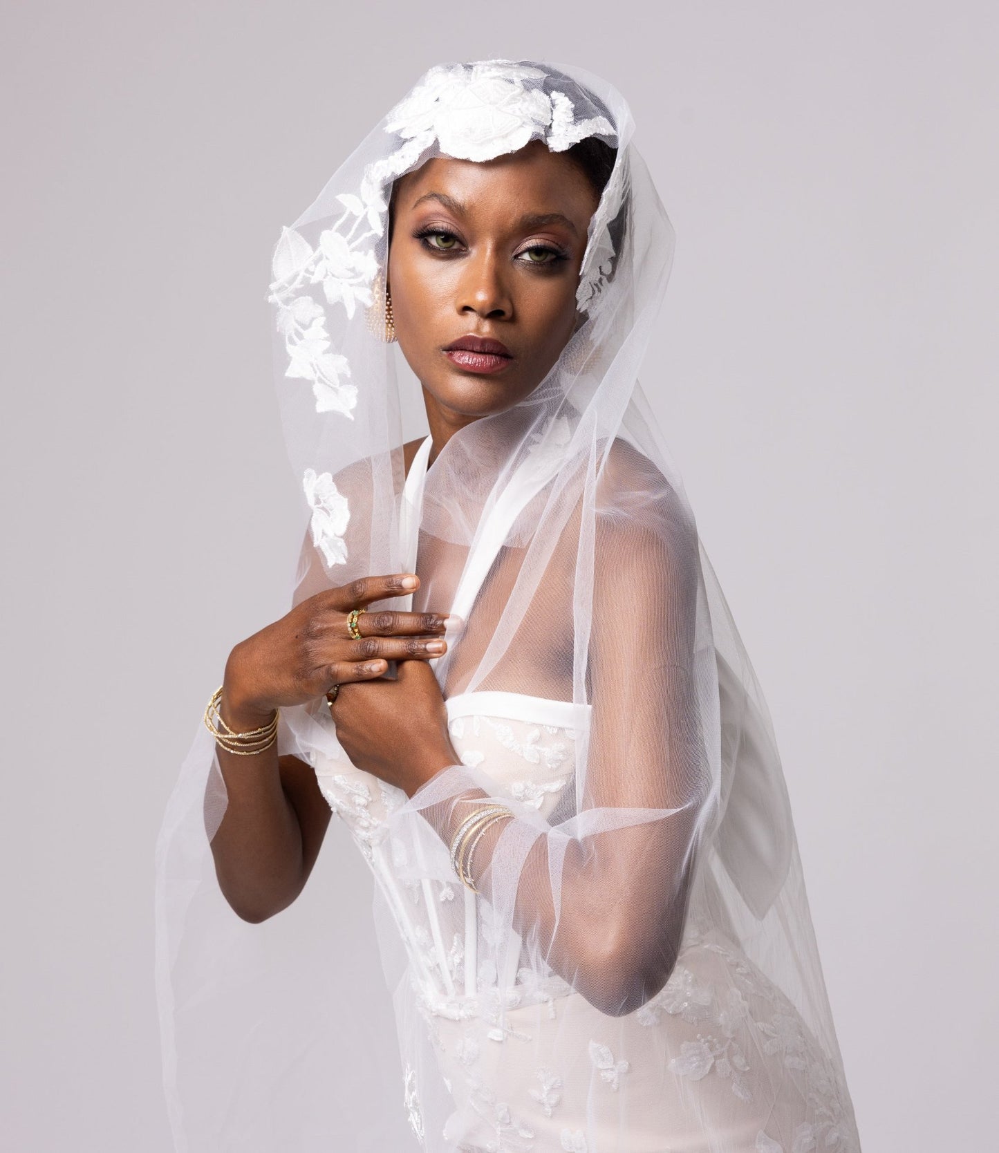 Nude underlay lace gown, white piping details, halter neckline with side slits. Large cascading bow in the back.