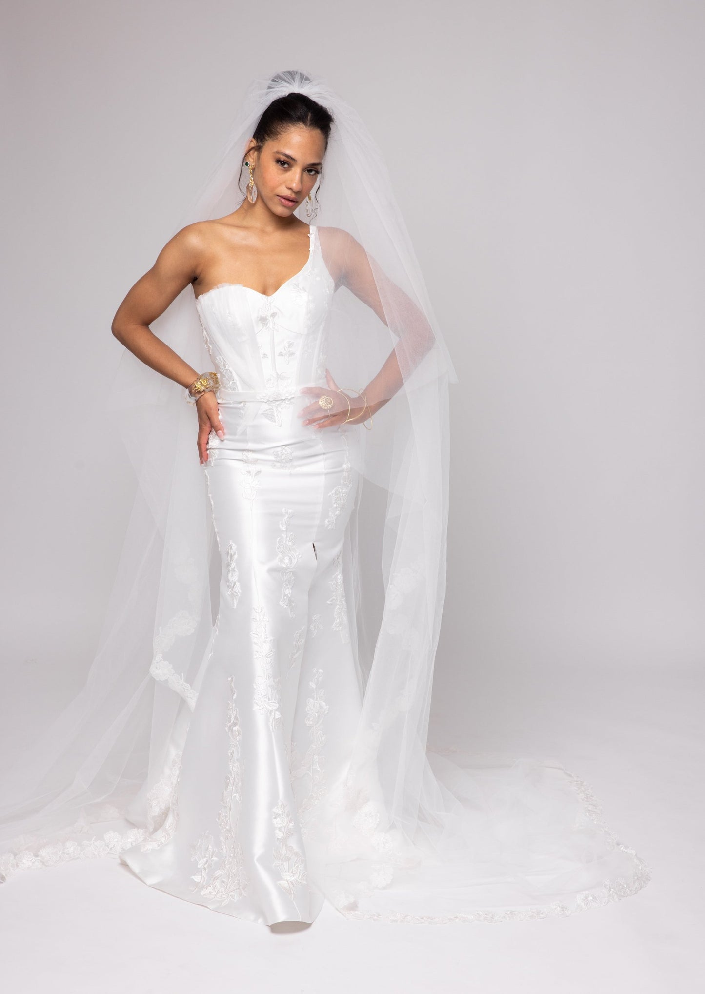 Off-white Mikado gown with embroidered lace, one shoulder with tulle detail over left bust. Detachable peplum.
