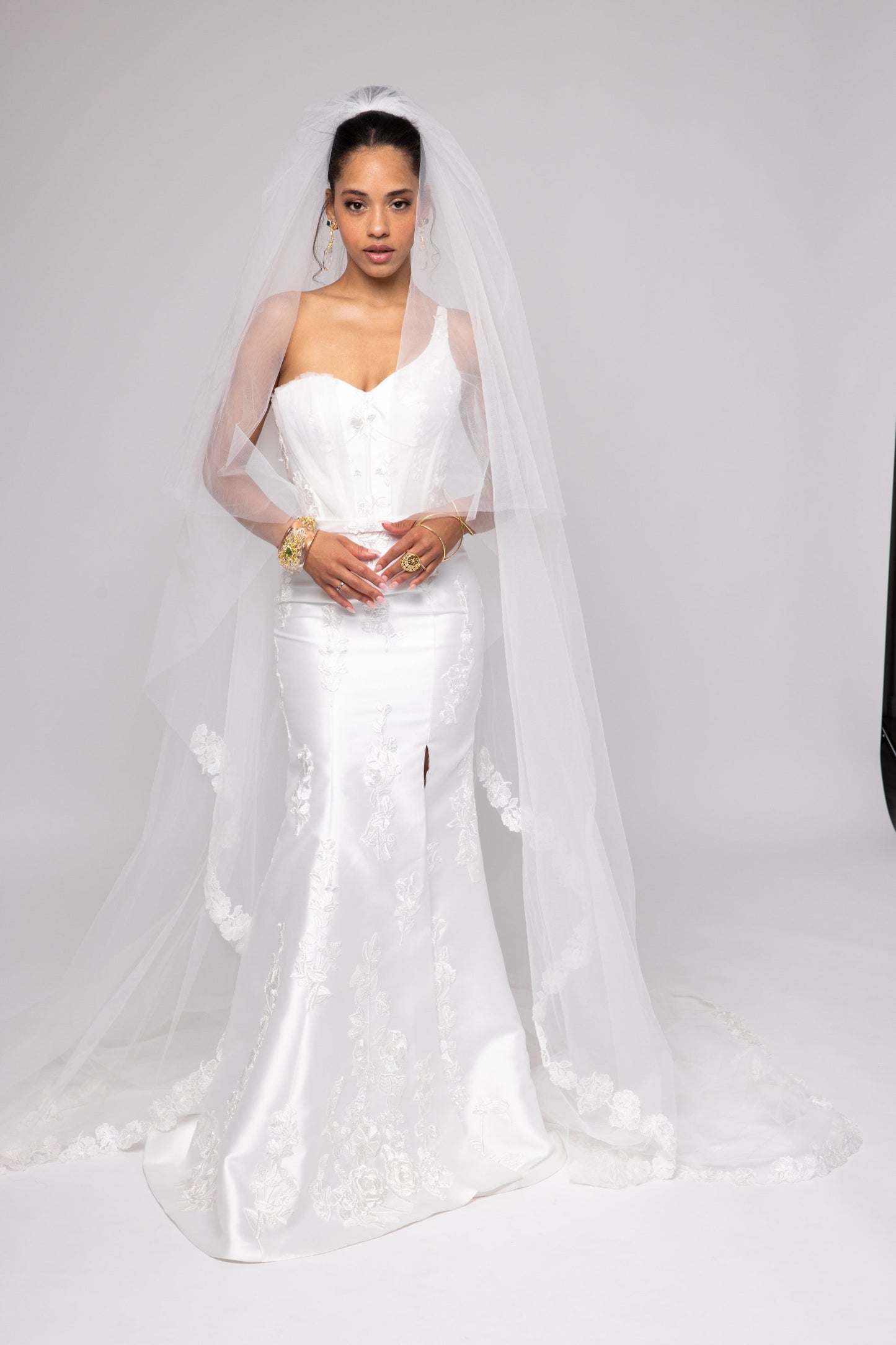 Off-white Mikado gown with embroidered lace, one shoulder with tulle detail over left bust. Detachable peplum.