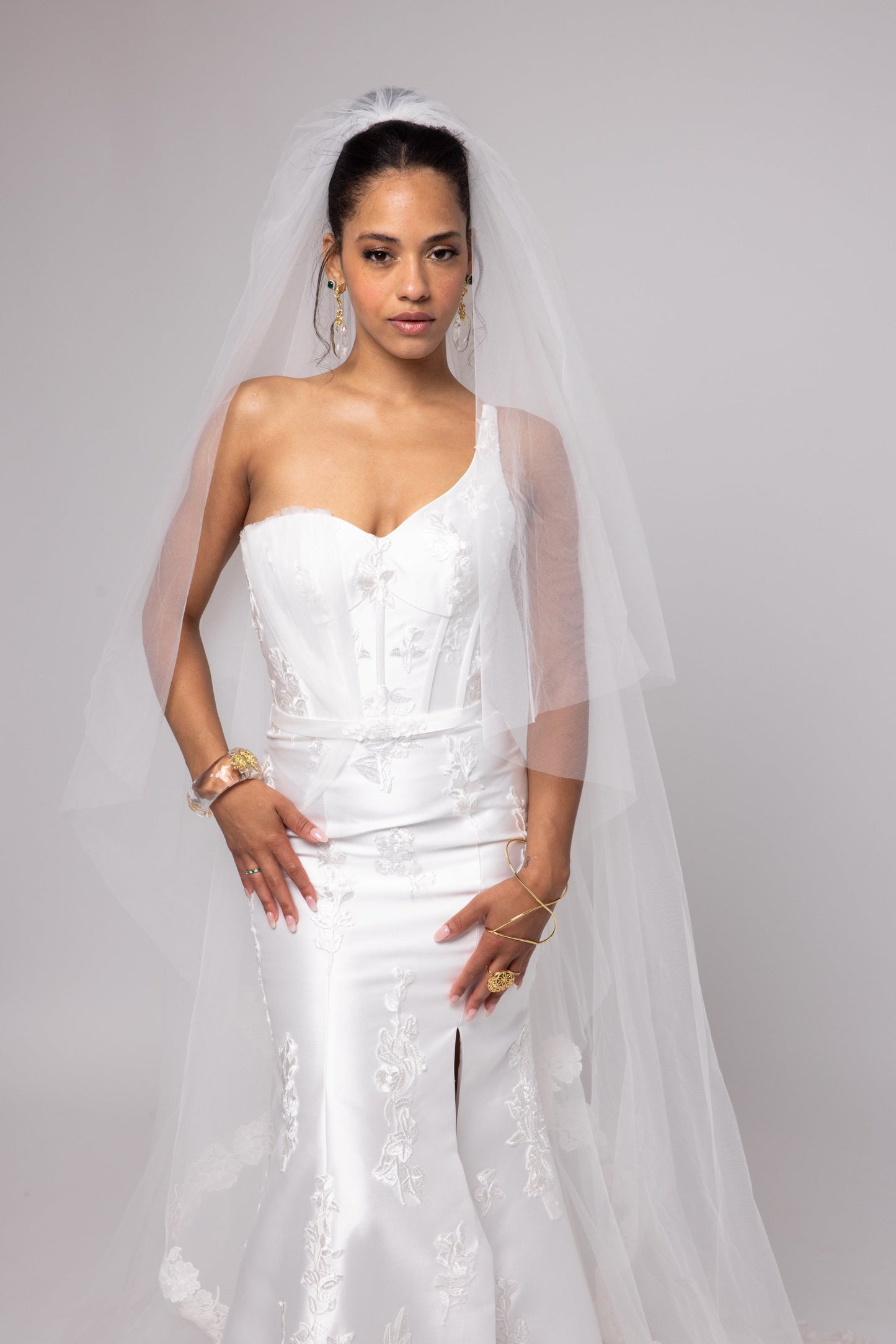 Off-white Mikado gown with embroidered lace, one shoulder with tulle detail over left bust. Detachable peplum.