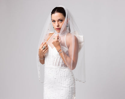 Off-white beaded Italian satin gown, halter jeweled neckline with large cascading double bow in the back.