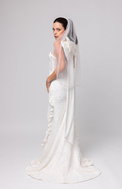 Off-white beaded Italian satin gown, halter jeweled neckline with large cascading double bow in the back.