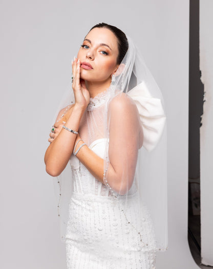 Off-white beaded Italian satin gown, halter jeweled neckline with large cascading double bow in the back.