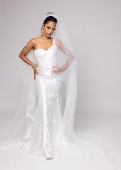 Off-white Mikado gown with embroidered lace, one shoulder with tulle detail over left bust.&nbsp; Detachable peplum.