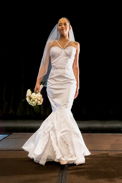 Chic halter gown with structured bust details and flared mermaid hemline with exposed tulle