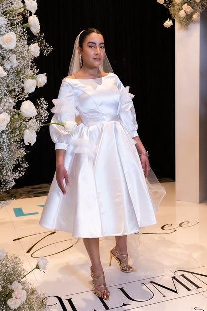 Knee length, boat neck dress of satin and tulle detailing.&nbsp; Three quarter sleeves, it is perfect as a day wedding or a fancy bridal shower dress.