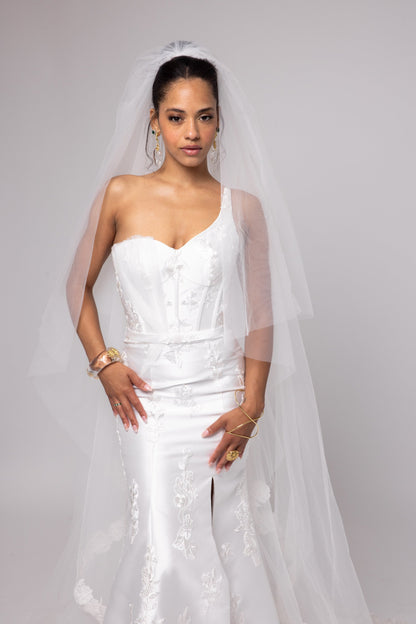 Off-white Mikado gown with embroidered lace, one shoulder with tulle detail over left bust.&nbsp; Detachable peplum.