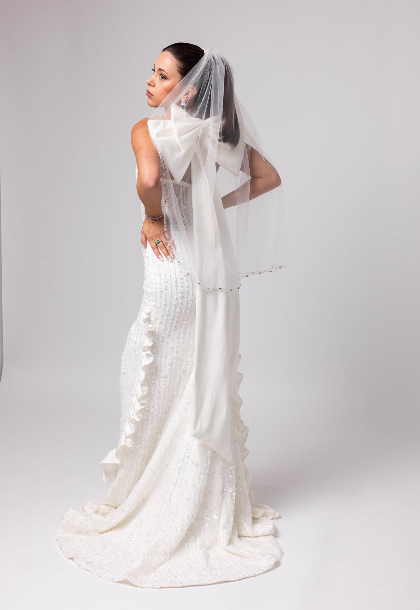 Off-white beaded Italian satin gown, halter jeweled neckline with large cascading double bow in the back.